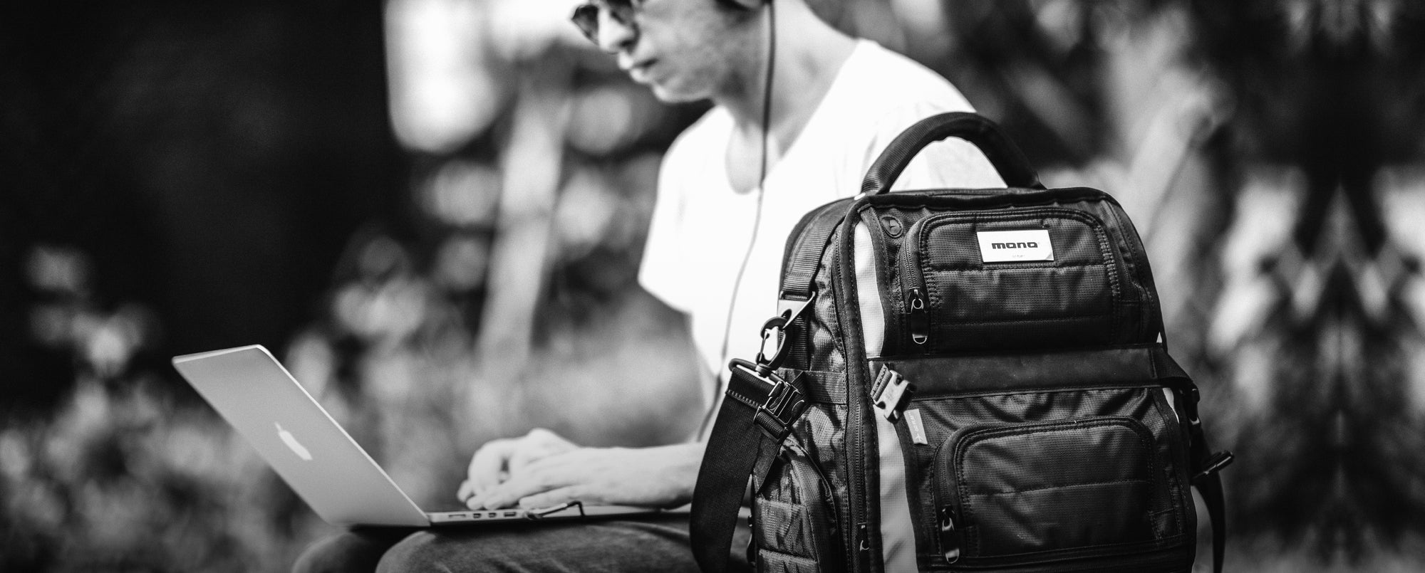 A man working on his laptop and with his MONO Classic FlyBy Backpack